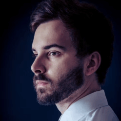 A man wearing a white button up with a purple tie.