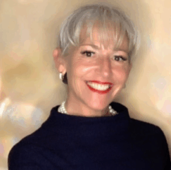 A woman wearing a black shirt with short white hair.